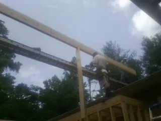 Carpenter setting a ridge beam over a new addition frame — Ice Dam Removal by Roofing Brothers in Marion Center