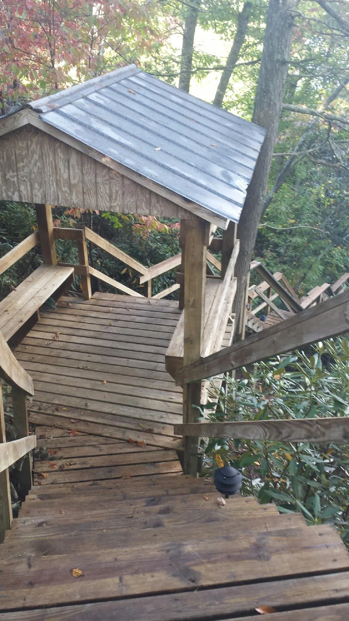 Metal roofed shelter over wooden steps on a wooded walkway — Skylight Repair & Installation work by our crew in Marion Center